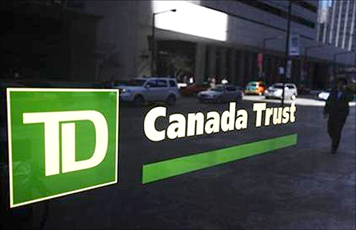 A Toronto-Dominion Canada Trust bank sign is seen as people walk by in Toronto,