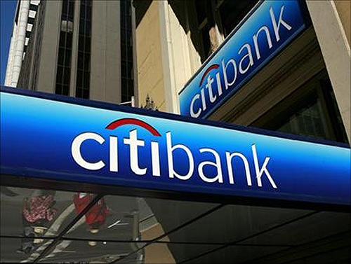 People walk beneath a Citibank branch logo in the financial district of San Francisco, California.
