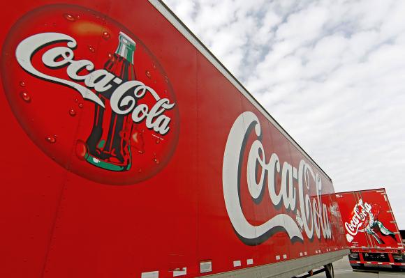 Trucks containing cases of Coca-Cola, which will be delivered to stores, sit outside a warehouse.