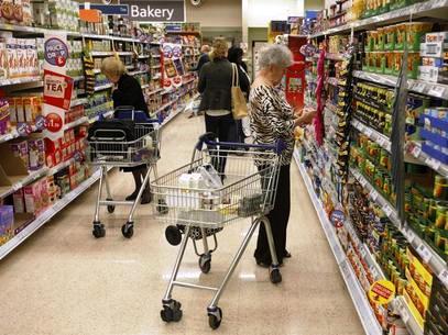Customers shop for groceries in a supermarket.