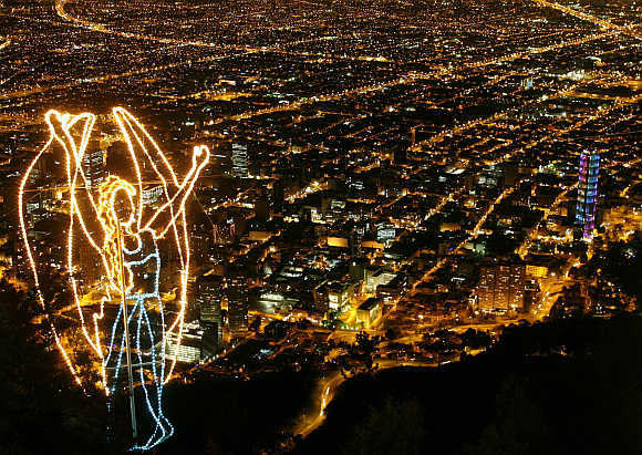 An illuminated Christmas decoration of an angel overlooks Bogota city in Colombia.