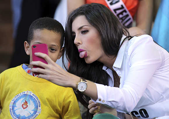 Miss Mexico 2011 Karin Ontiveros jokes with a boy as she takes a photograph in Sao Paulo, Brazil.