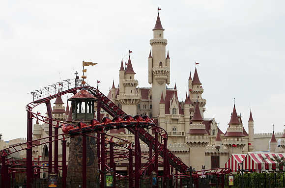 People ride in a roller coaster at the Universal Studios theme park in Singapore.