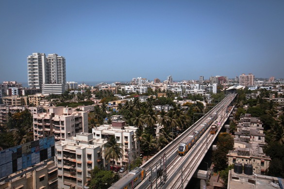 Metro trains pass through a residential area during its first official safety trial run in Mumbai.