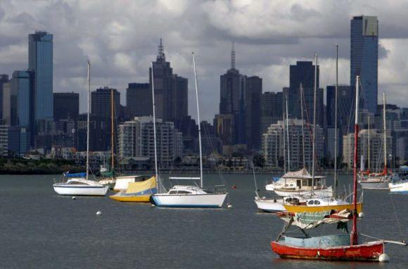 Sailboats dock in front of the Melbourne skyline.