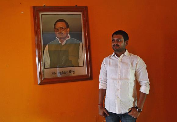 Sanjeev Singh, scion of the Singh Mansion, a dynasty of union leaders and coal traders, poses in front of a portrait of his father.