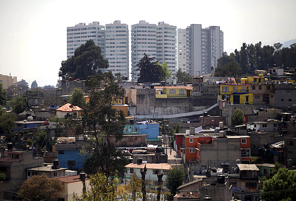New buildings are seen behind a low-income neighborhood in Mexico City.