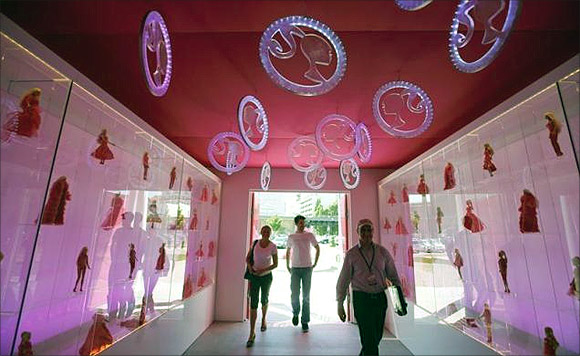 People enter a life-size Barbie Dreamhouse of Mattel's Barbie dolls during a media tour in Berlin.