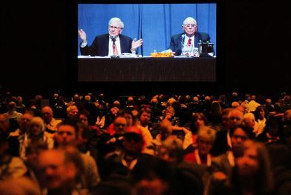 Berkshire Hathaway shareholders listen as Chairman Warren Buffett (L) and Vice Chairman Charlie Munger, seen on a video screen, answer questions at the company's annual meeting in Omaha.