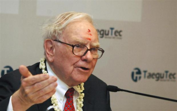 Billionaire Warren Buffett, wearing a traditional tikka or a red mark on the forehead, speaks during a news conference in Bangalore.