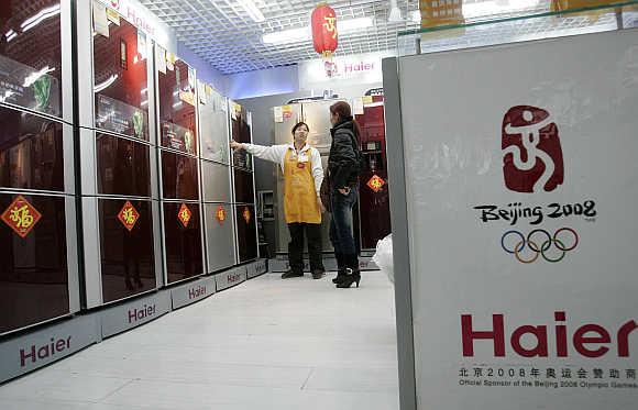 A salesperson recommends a refrigerator to a customer at a Haier store in Shanghai.