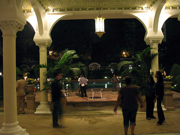 Guests walk by the poolside area of Taj Mahal hotel in Mumbai.