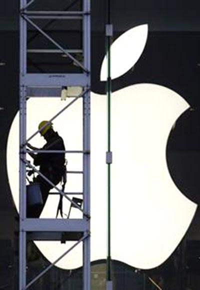 A worker climbs outside an Apple store in Hong Kong.