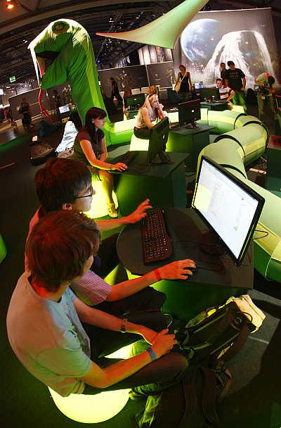 Visitors play at an exhibition stand at the Games Convention Online fair in the eastern German city of Leipzig.