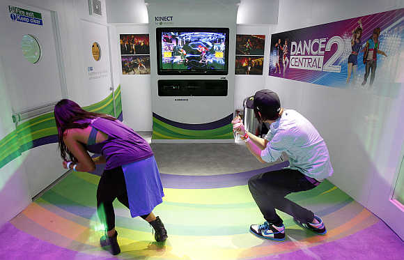 Attendees play the Dance Central 2 for the Xbox 360 Kinect in Los Angeles, California.
