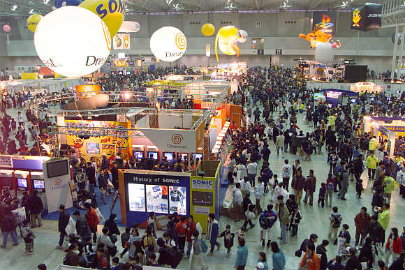 Children and their parents look over video game software at the World Hobby Fair in Makuhari, east of Tokyo, Japan.