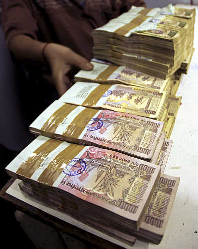A bank employee counts bundles of rupee notes at a cash counter in Agartala, Tripura.