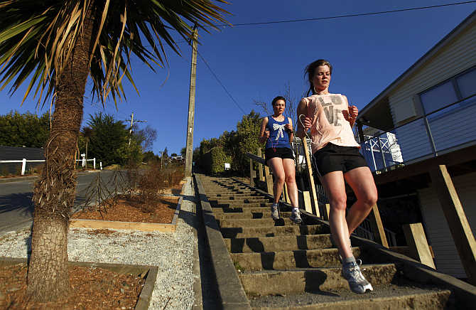 Women run down Baldwin street in Dunedin, New Zealand. Baldwin street is considered as one of the world's steepest streets.