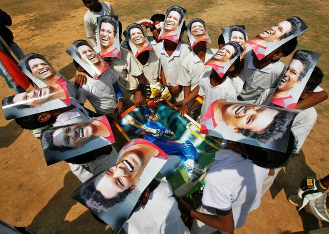 Boys from a local cricket academy wearing masks of Indian cricketer Sachin Tendulkar, celebrate his 100 international centuries in Agartala.