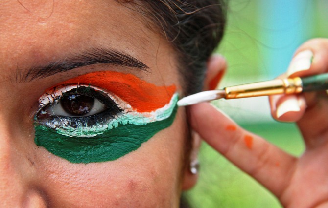 A college girl gets her eye painted in tri-colours of India's national flag.