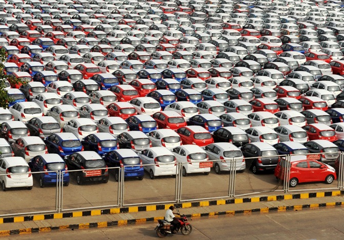 A man rides his motorbike past parked Hyundai cars ready for shipment at a port in the southern Indian city of Chennai.