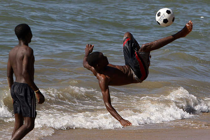 Boys play soccer at the beach in Benguela, Angola.