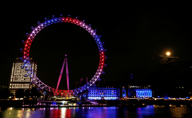The London Eye is lit in red, white and blue and the full moon is visible after Catherine, Duchess of Cambridge gave birth   to a baby boy at St Mary's Hospital in central London, July 22, 2013. 
