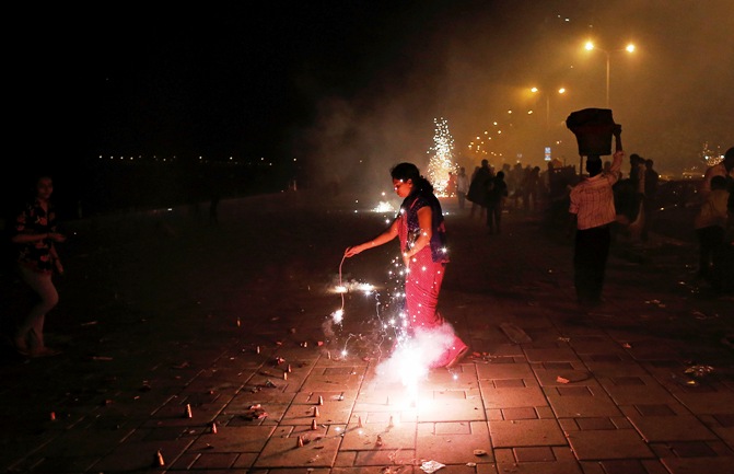 A woman lights firecrackers celebrating the Hindu festival of Diwali, the annual festival of lights, in Mumbai November 3, 2013.