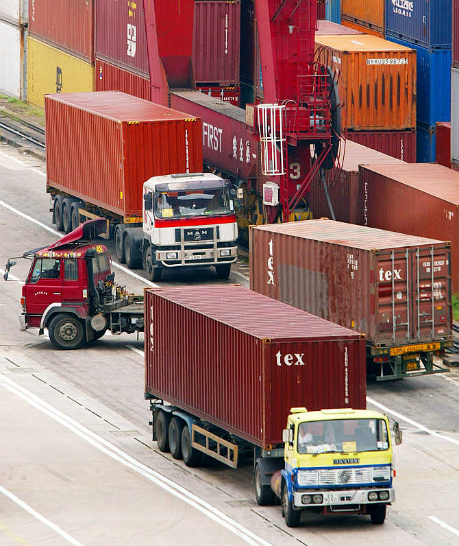 Loaded trucks leave a Hong Kong container terminal.