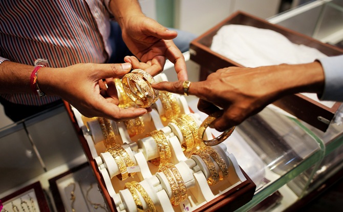 An employee shows gold bangles to a customer at a jewellery showroom in Mumbai.