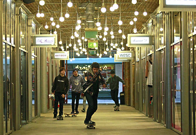Youths skateboard through a shopping arcade at Covent Garden in London, United Kingdom.