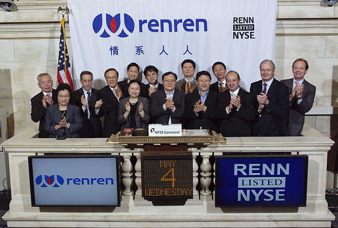 China's Renren Chairman and Chief Executive Officer, Joseph Chen, centre, is joined by executives and guests as he rings the opening bell at the New York Stock Exchange.