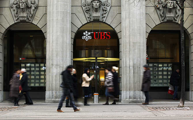 People walk in front of a branch of Swiss bank UBS in Zurich.