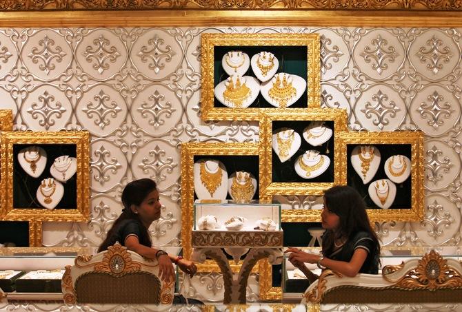 Employees wait for customers inside a gold jewellery showroom in New Delhi.