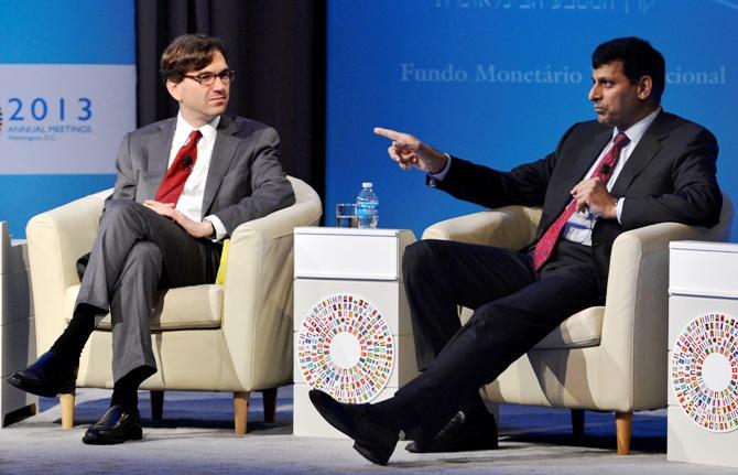 Reserve Bank of India Governor Raghuram Rajan (R) gestures as he responds to a question as Chairman of the Council Economic Advisers Jason Furman listens during a CNN Debate on the Global Economy, as part of the IMF and World Bank's 2013 Annual Fall Meetings, in Washington October 10, 2013.