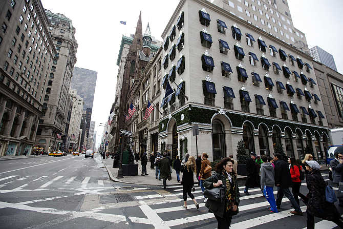 Pedestrians walk past the Harry Winston jewellery store, right, on 5th Avenue in New York, United States.