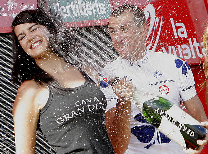 Anthony Roux of France celebrates with champagne after a cycling race in Spain.