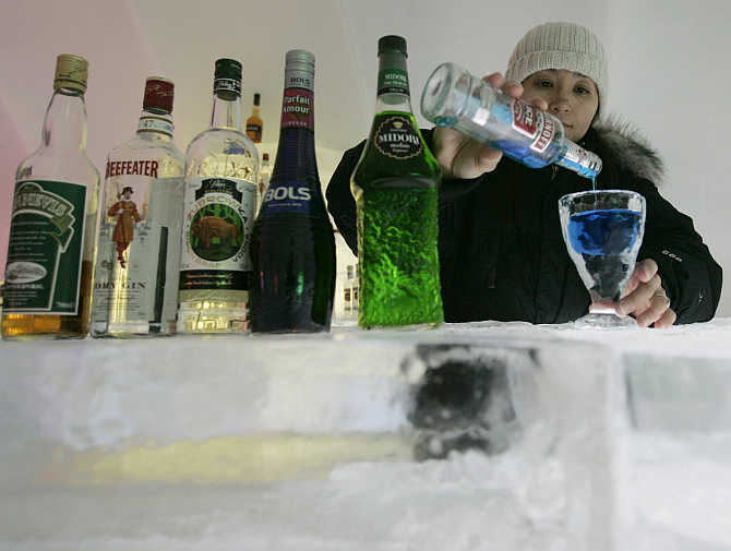 A bartender pours vodka into an glass made of ice at Alpha Resort Tomamu's ice village in Shimukappu town, Japan's northern island of Hokkaido.