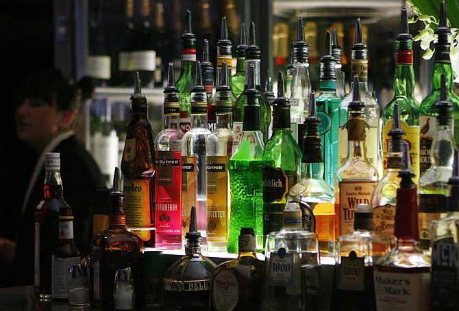 A bartender walks next to liquor bottles in a bar in central Sydney, Australia.