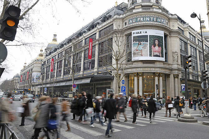 People walk past the Printemps department store in Paris, France.