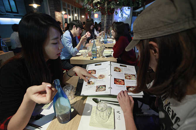 Diners look at a menu at a dining bar in the Gangnam area of Seoul, South Korea.