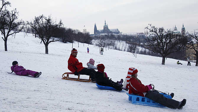 People slide down a snow covered Petrin hill in Prague, Czech Republic.