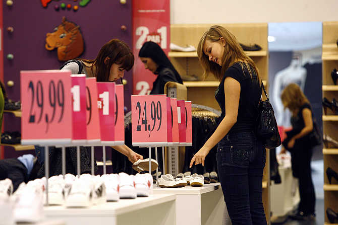 Women look at shoes in a shopping centre in Riga, Latvia.