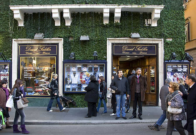 People walk in front of a shop in downtown Rome, Italy.