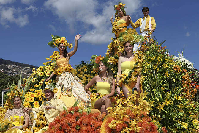 People participate in a parade on a float at the Madeira Island Flowers Festival in Funchal, Portugal.