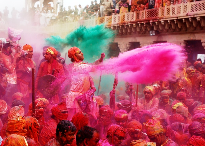 People throw coloured powder as they celebrate 'Lathmar Holi' at Nandgaon village in Uttar Pradesh.