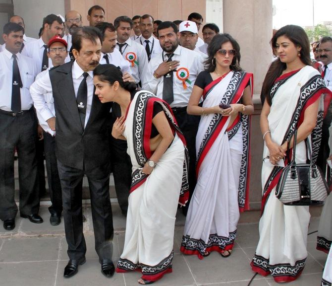 Sahara Group Chairman Subrata Roy (front, L) speaks with an employee before they sing India's national anthem in Lucknow.