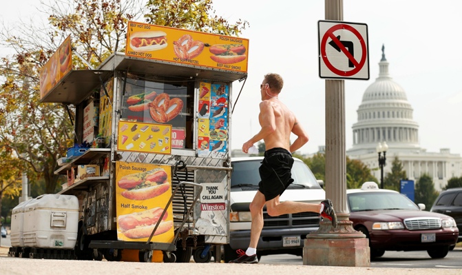 A jogger passes a street food vendor next to the US Capitol in Washington on October 3, 2013. 