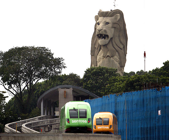 Monorail vehicles pass in front of the Merlion statue on Singapore's Sentosa Island.