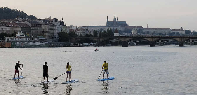 People paddle on their boards on the Vltava river in central Prague, Czech Republic.
